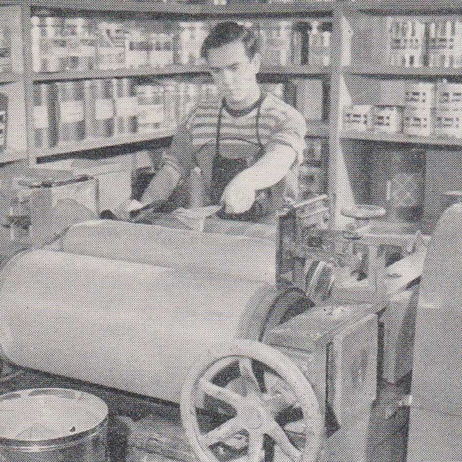 Black and white photograph taken of an employee blending inks on an ink mill.