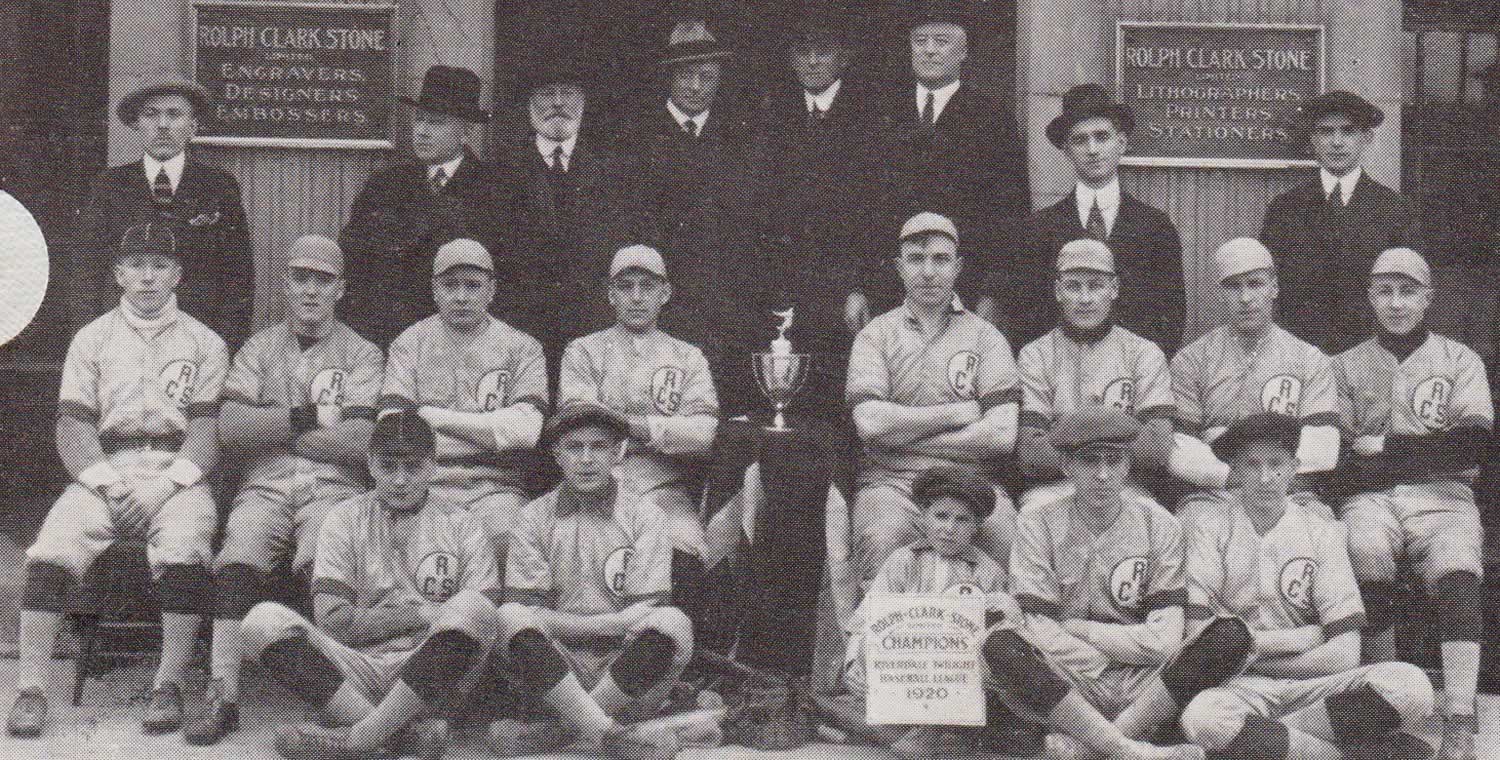 Black and white baseball team photograph in front of the Rolph-Clark-Stone pillared entrance. The first two rows are wearing baseball jerseys. The men in the last row are wearing black suits and hats.